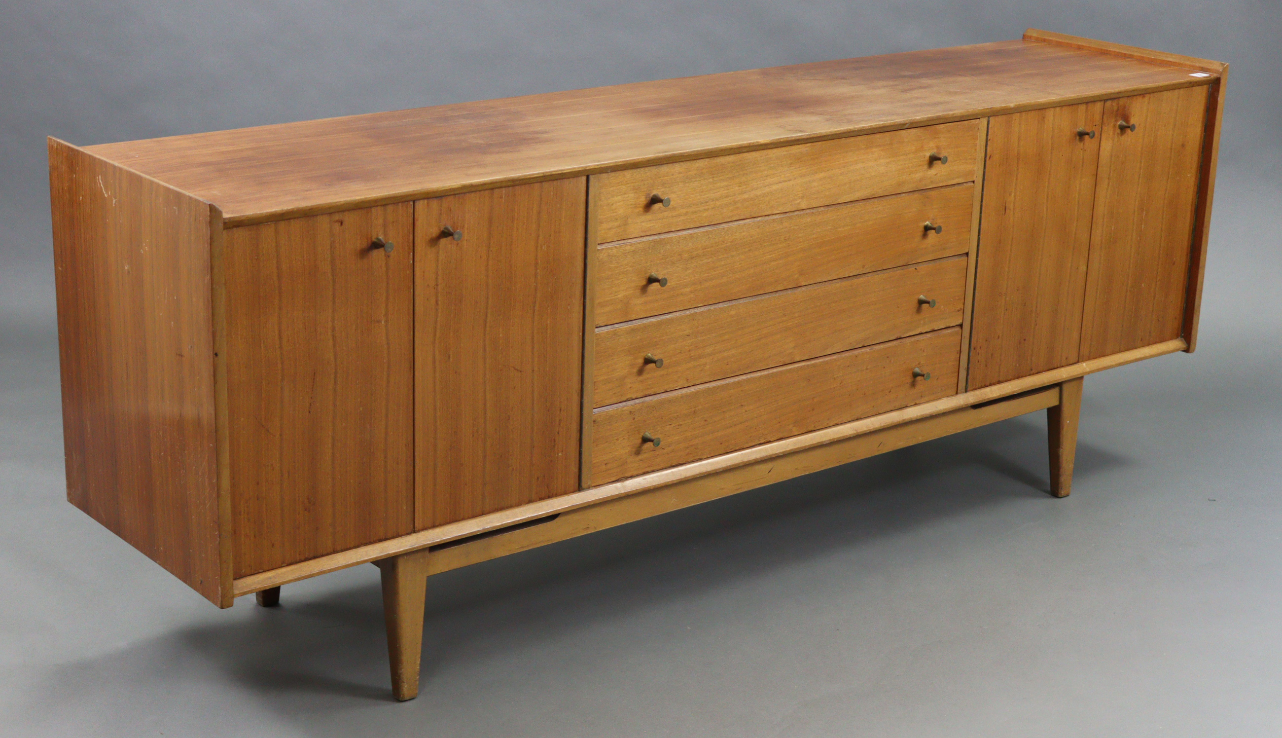 A Younger’s teak sideboard, fitted four long graduated drawers to centre flanked by cupboard to