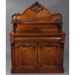 A Victorian mahogany chiffonier with carved foliate scroll decoration to the stage back, fitted