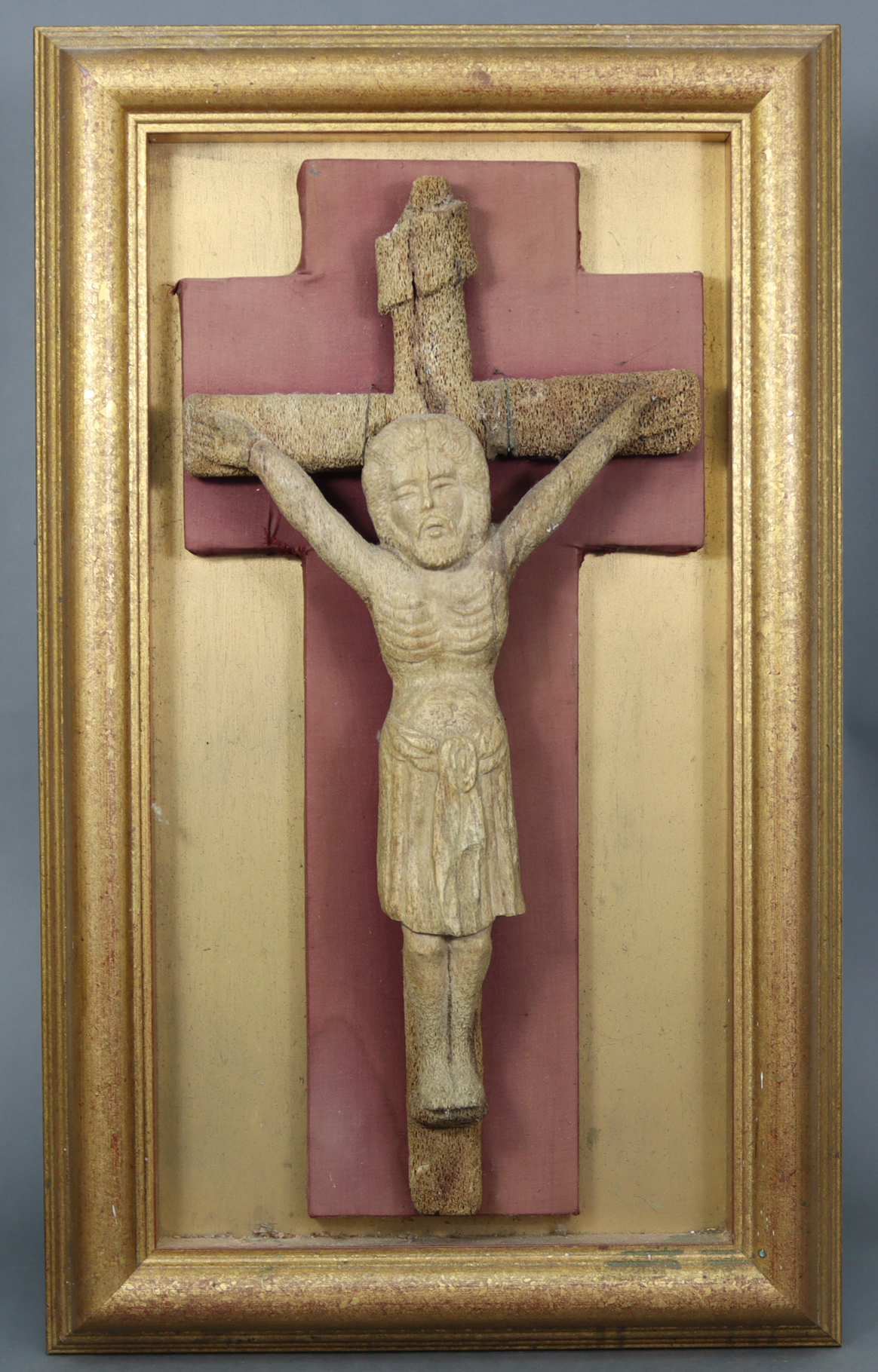 An early carved bone Corpus Christi, 20½” x 10”, mounted on burgundy silk-lined backing, & in open