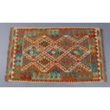 A Choli Kilim rug with multicoloured repeating lozenge motifs to the centre within a geometric