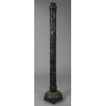An early 20th century eastern carved & pierced ebonised wooden torchere/standard lamp, the