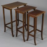 An Edwardian inlaid mahogany nest of three rectangular occasional tables on square splay legs, 20”