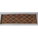 A Suzni Kilim runner of ochre ground, with repeating lozenge designs to the centre within a narrow