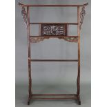 A Chinese carved hardwood clothes rail, with pierced foliate central panel & archaic style supports;