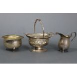 A silver oval sweetmeat basket with pierced scroll sides, swing handle, & on oval pedestal foot, 5½”