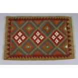 A Maimana Kilim rug of ochre ground, with repeating lozenge motif to the centre with in a narrow