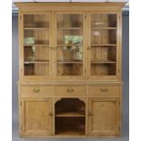 A Victorian pine dresser, the upper part with moulded cornice, above three shelves enclosed by three