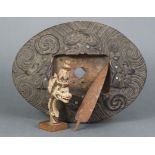 An antique Maori carved wooden oval panel (formerly a base or stand) with stylised decoration &