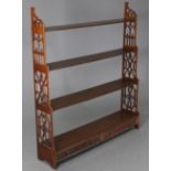 An early Victorian mahogany wall hanging waterfall bookcase, of four open graduated tiers, fitted