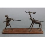 A 19th century African tribal bronze group depicting a warrior with his gun confronting a beast, on