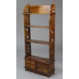 A Victorian style mahogany small standing open bookcase of four tiers, on pierced fret-carved end