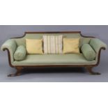 A Regency mahogany scroll-end settee with foliate carved panel to the shaped back-rail, reeded