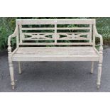 A teak slatted garden bench with shaped open arms, & on turned front legs, 47¼” long.