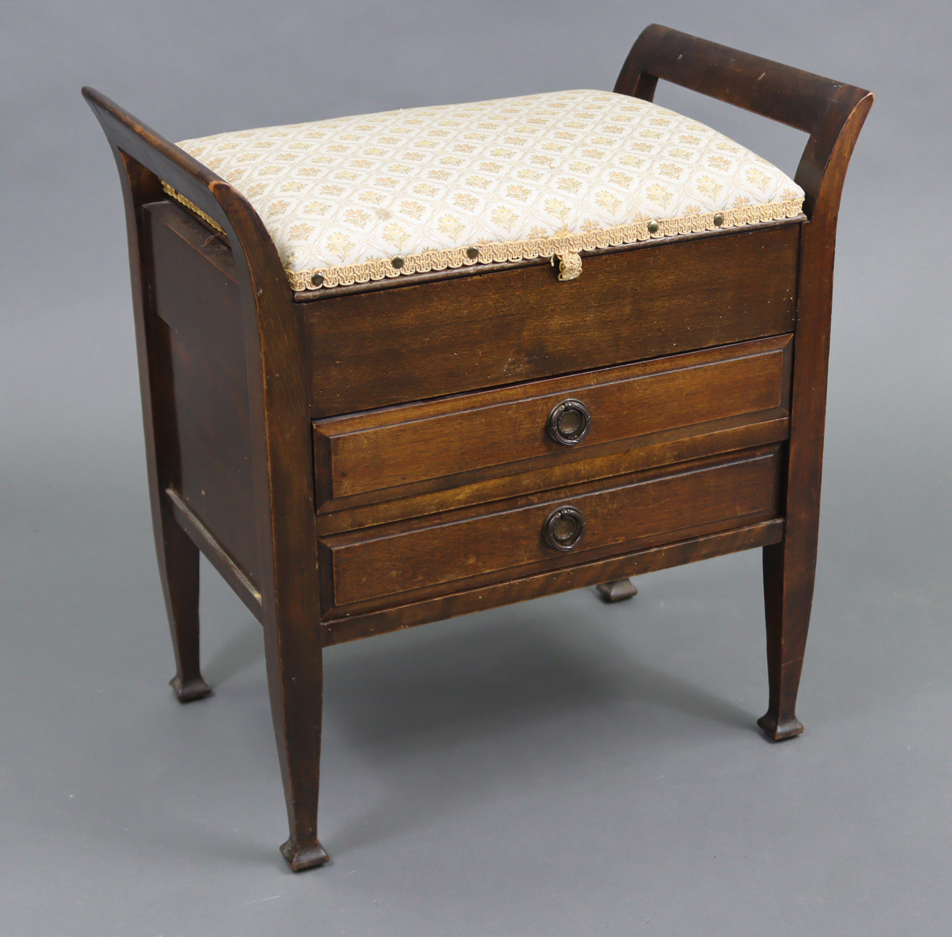 An Edwardian beech piano stool with padded hinged seat above two long drawers with hinged