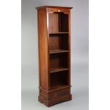 A hardwood tall narrow standing open bookcase fitted three shelves above a long drawer, & on a