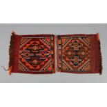 A pair of Afghan small rugs or saddlebag faces, each of madder ground with repeating lozenge &