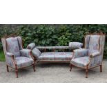 An Edwardian beech-frame three-seater settee with padded seat, back, & scroll arms upholstered