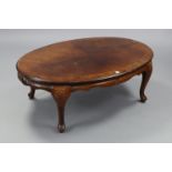 A walnut low coffee table with oval top, & on short cabriole legs & pad feet, 44” wide x 16” high