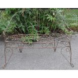 A Victorian-style wrought-iron two-seater garden bench with pierced scroll decoration, & on shaped