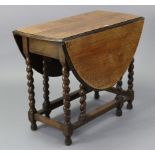 A 1930’s oak oval gate-leg dining table on barley-twist legs & turned feet with plain stretchers,