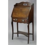 An Edwardian inlaid-oak small bureau with fitted interior enclosed by fall-front above a long