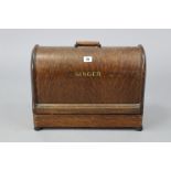 A singer hand sewing machine with oak carrying case.