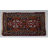 A Turkish small rug of deep blue ground, with central panel of two lozenges within crimson & ivory