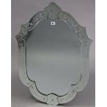 A Venetian-style shield-shaped wall mirror with bevelled edge & having etched floral border, 24¾”