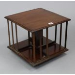 A mahogany square revolving table-top bookcase, 14½” wide x 13” high; & a brass-finish foldaway