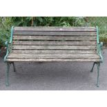 A teak slatted garden bench on green painted cast-iron end supports, 50” long.