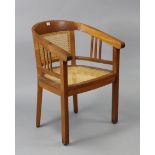 A teak tub-shaped chair inset woven-cane panel to the seat & back, & on square tapered legs.