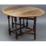 A 1930’s oak oval gate-leg dining table on barley-twist legs & turned feet with plain stretchers,