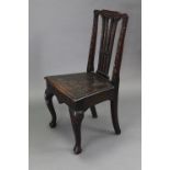 A late 19th/early 20th century carved oak splat-back hall chair with hard seat, & on cabriole legs &