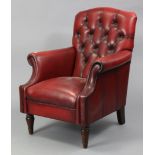 A red leather buttoned-back armchair on short turned legs.