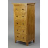 A modern light oak small upright chest fitted five long drawers, 19½” wide x 43½” high x 15” deep.
