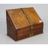 A late 19th century walnut sloping-front stationery cabinet, with fitted interior enclosed by pair