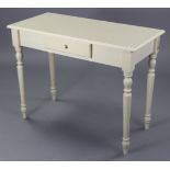 A white-finish side table fitted centre frieze drawer, & on four turned legs, 39” wide x 30” high