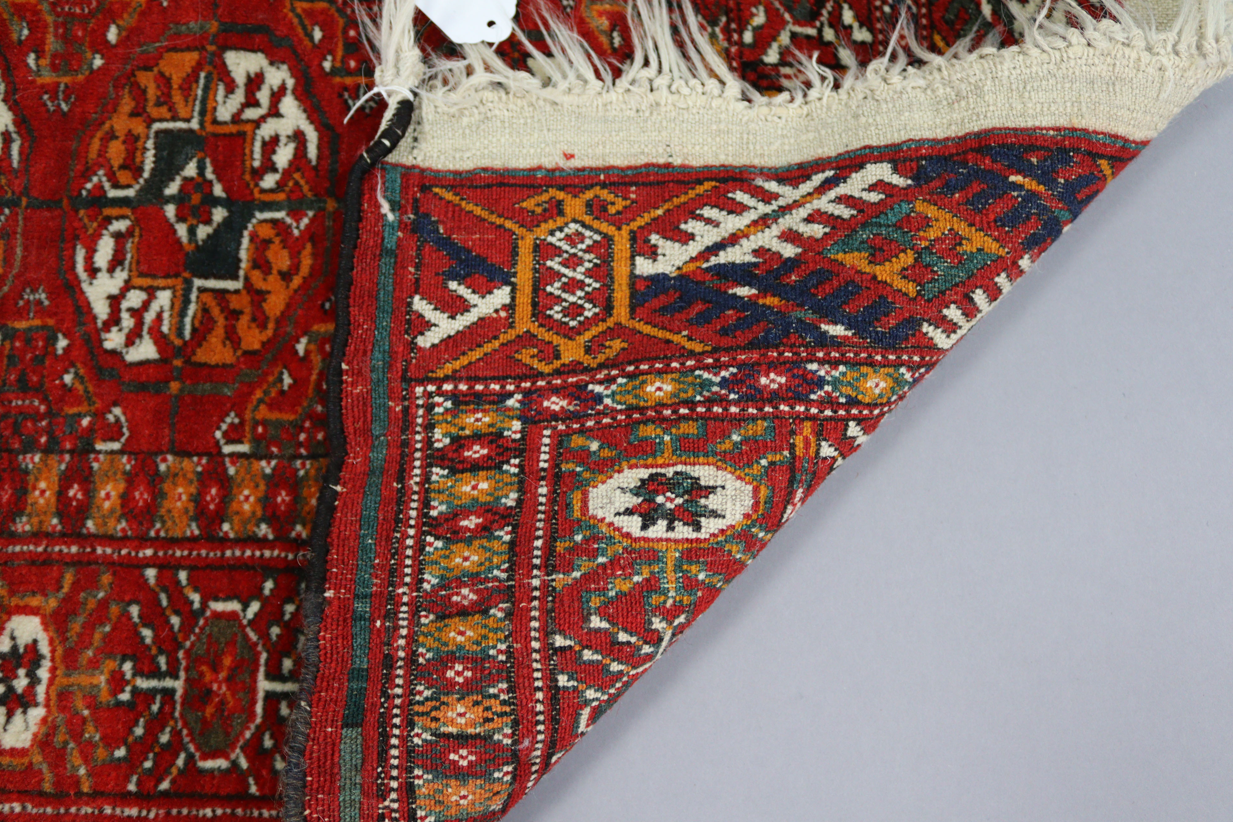 A Bokhara rug of crimson & ivory ground with three rows of guhls to centre within a wide border, 60” - Image 3 of 4
