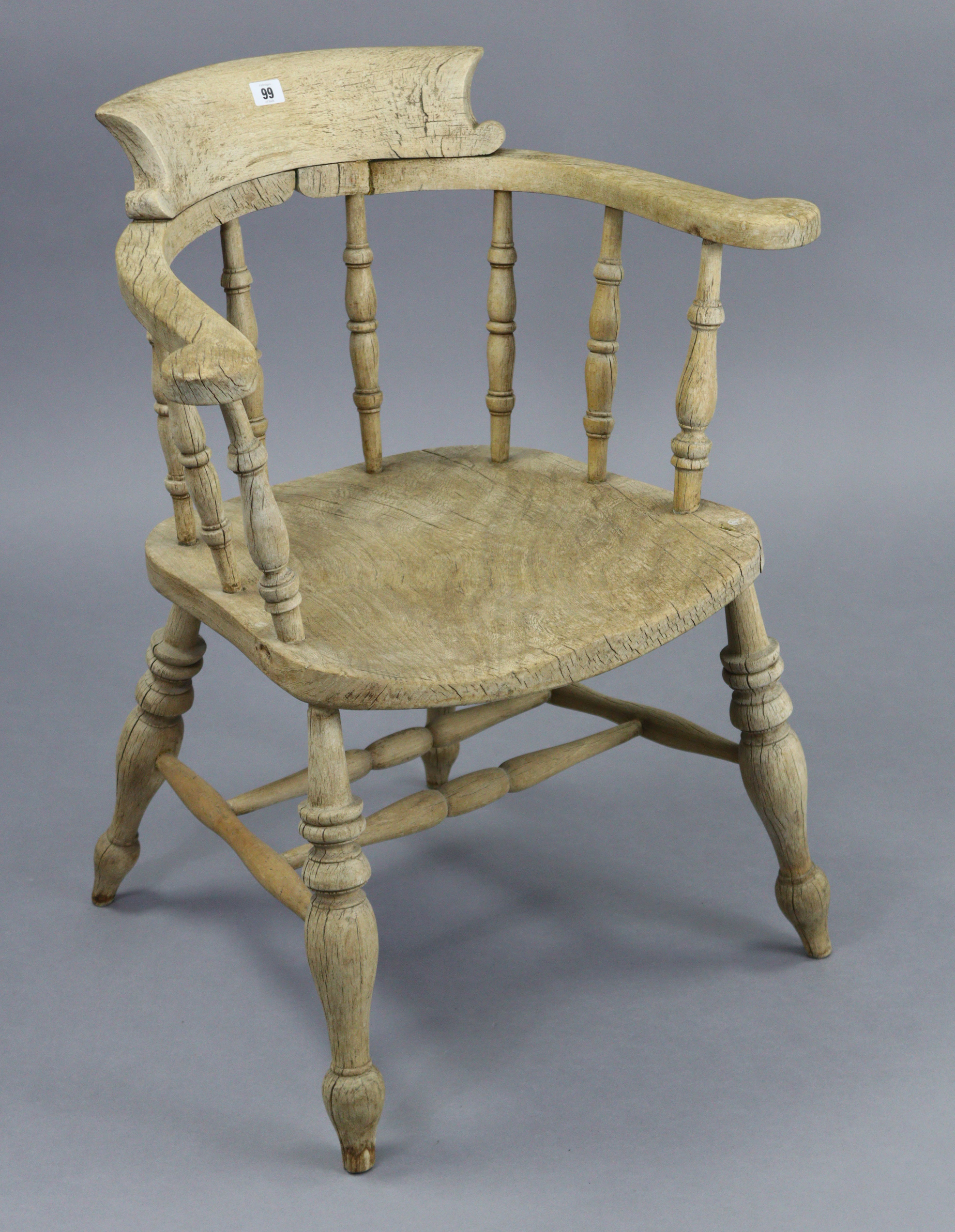 A spindle-back captain’s chair with hard seat, & on turned legs with spindle stretchers.