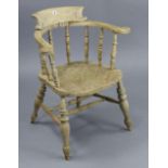 A spindle-back captain’s chair with hard seat, & on turned legs with spindle stretchers.