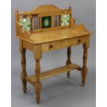 A pine washstand, inset tiles to the stage back, fitted frieze drawer, & on turned legs with open