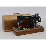 A Singer hand sewing machine with oak case.