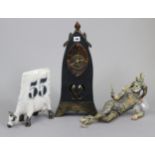 A mantel clock in black glazed pottery case, 19¼” high; a contemporary pottery model of a cow,
