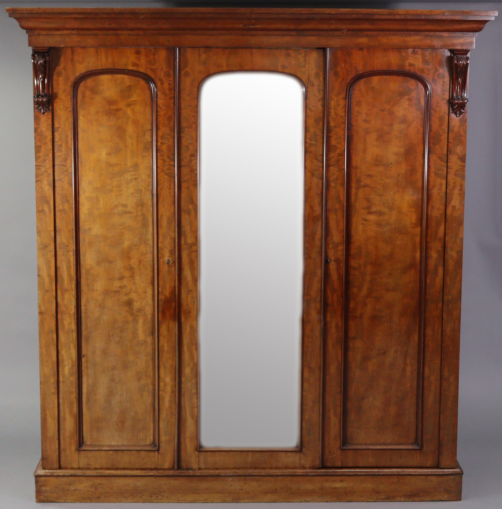 A Victorian hanging mahogany wardrobe with moulded cornice, enclosed centre mirror door, a panel