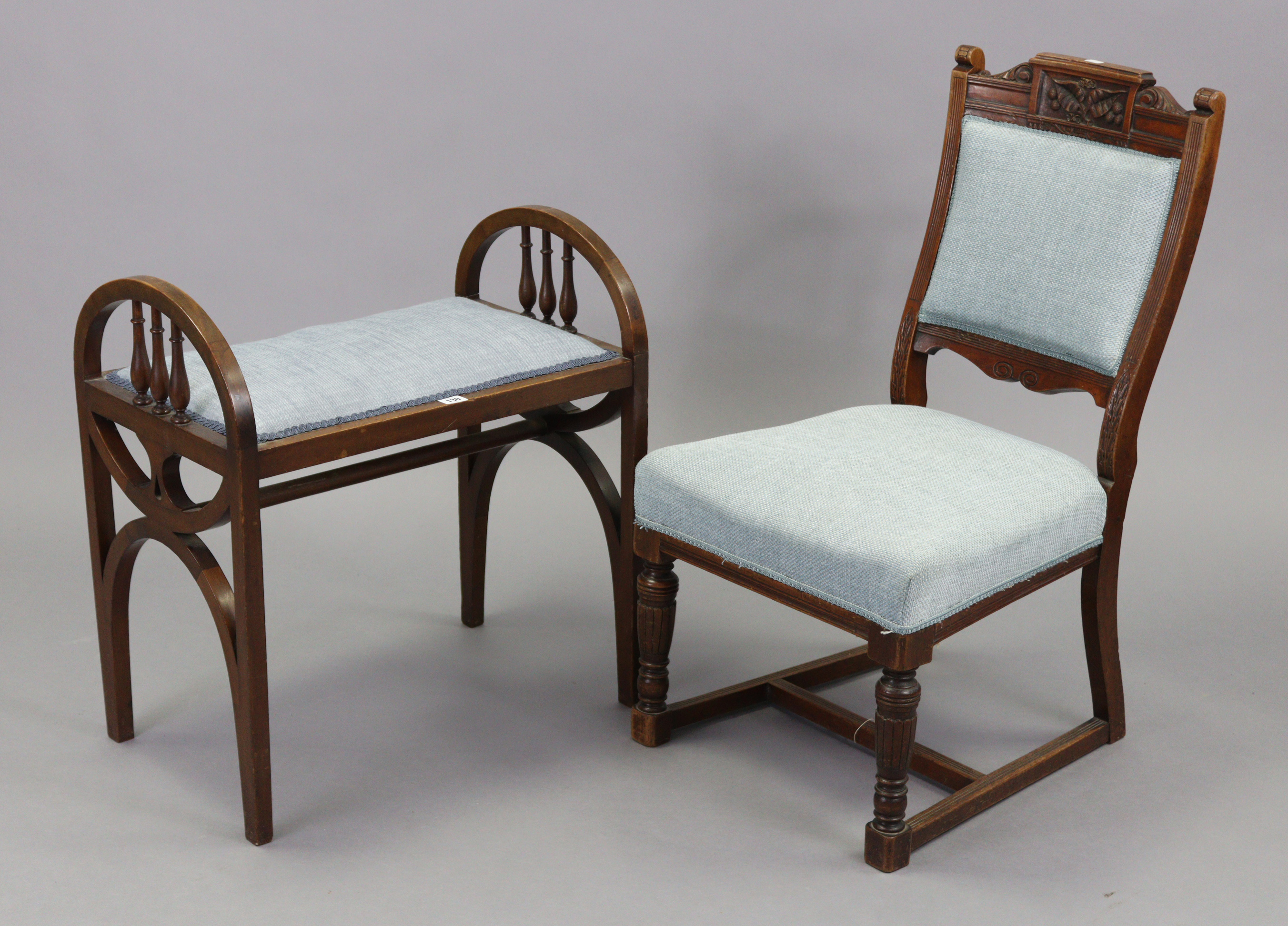 An Edwardian mahogany piano stool with padded seat, spindle-rail to each arm support, & on shaped