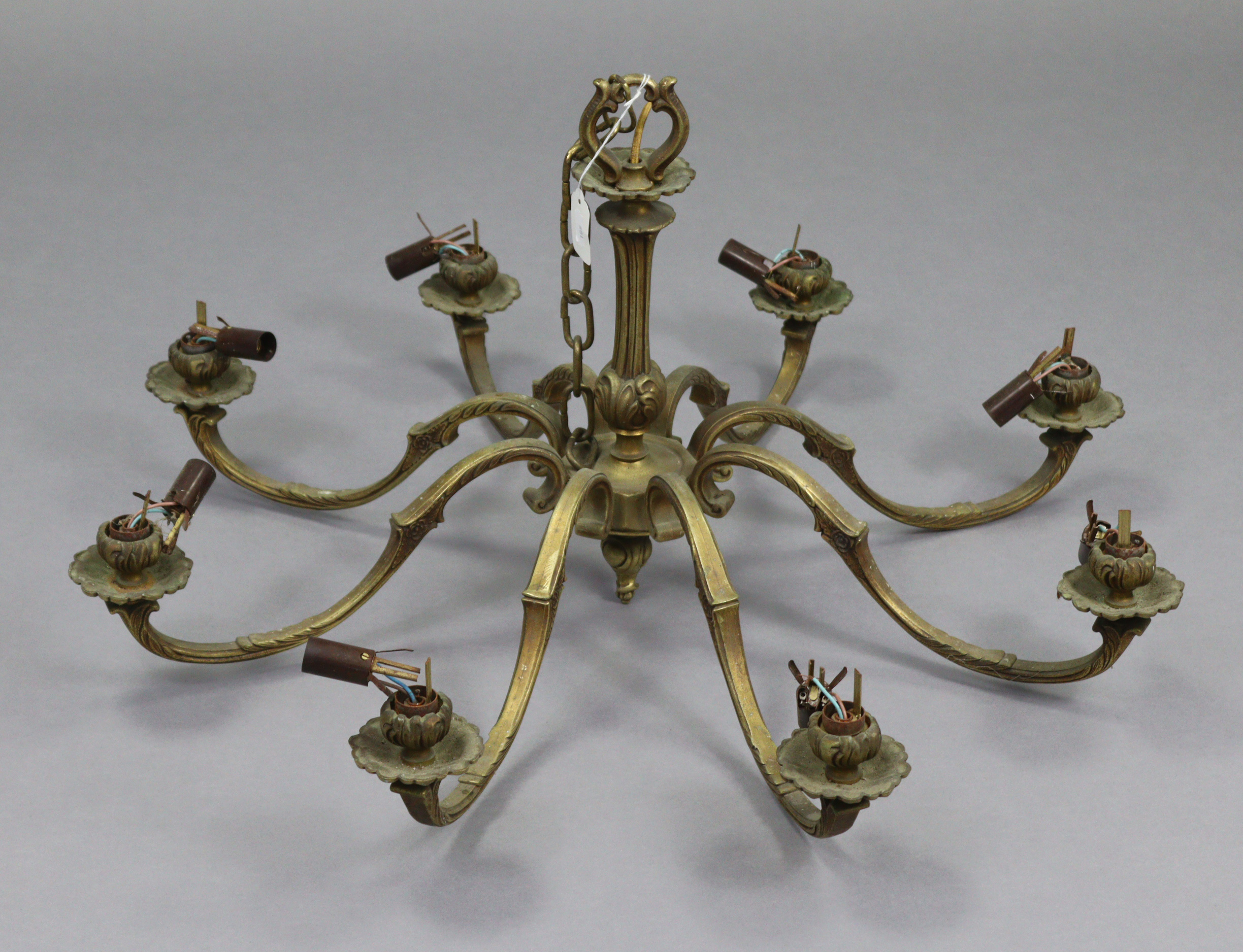 A brass eight-branch chandelier with scroll-arms, 30” wide x 15” high.