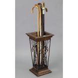 A mahogany-finish umbrella stand, 11½” wide x 22½” high; together with six walking canes; & a