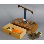 A pair of brass Class B portable beam scales to weigh 56gms, with weights, & in a fitted mahogany