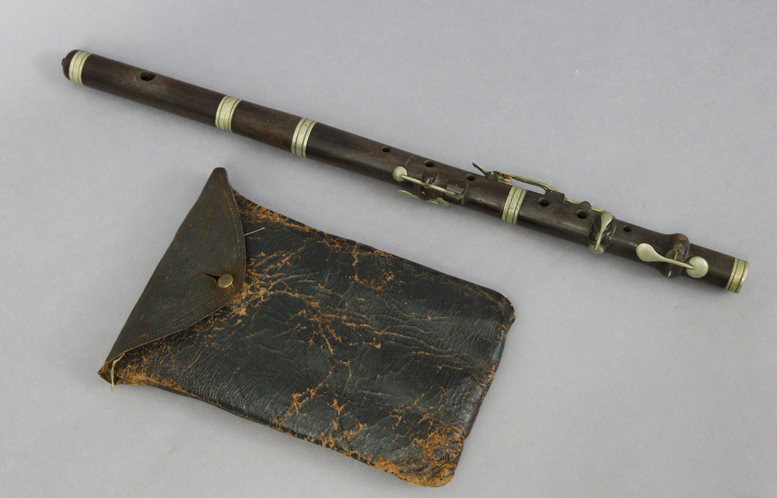 A rosewood flute (lacking mouthpiece) with chrome-plated keys, 19½” long, with case.