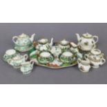 A Crown Staffordshire bone china eight-piece doll’s tea set, with oriental river landscape
